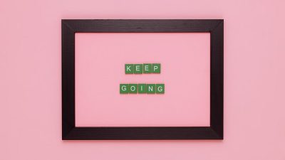 A framed motivational quote on a pink background for inspiration.